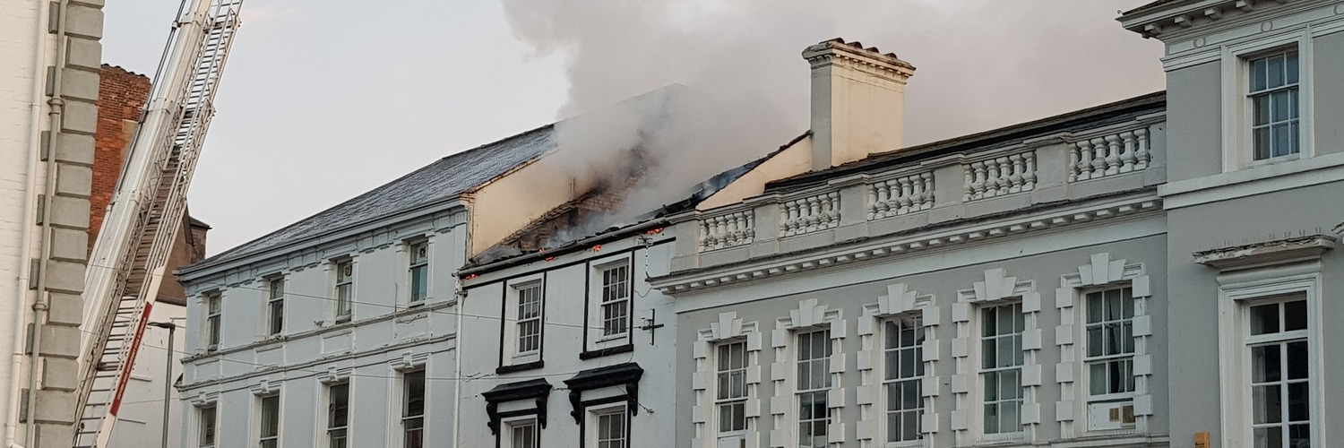 Roof of terraced commercial building on fire. Buildings Reinstatement Valuations